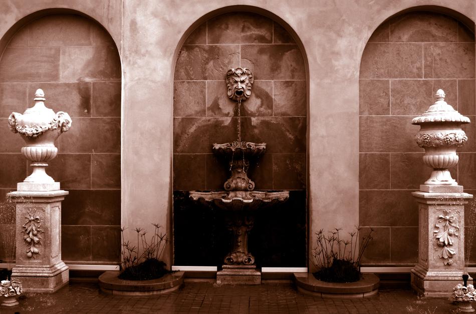 fountains with sculptures near the wall