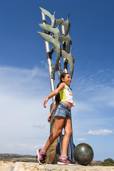 girl posing on a background of metal sculpture