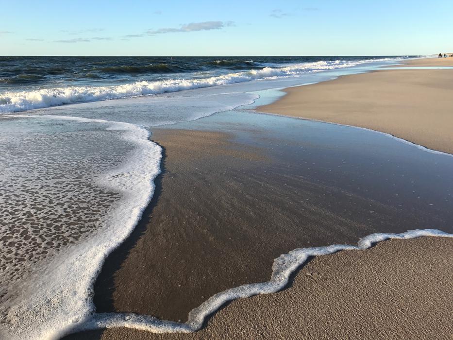 white sea surface of water on a sandy beach