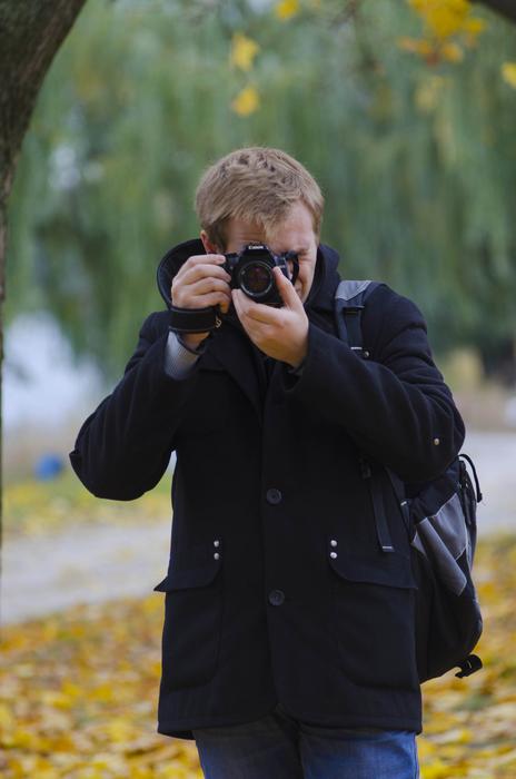 portrait of man with photo camera in park at fall