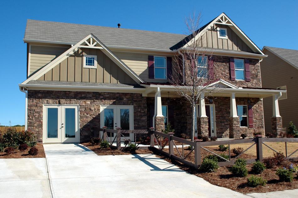 Beautiful new home with the columns, in sunlight, under the blue sky