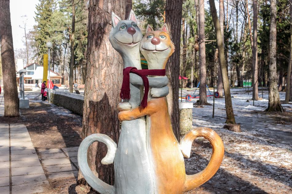 sculpture of two hugging cats in the park
