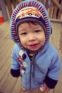 Portrait of the cute, smiling boy, covered in the colorful hood