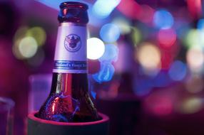 beer bottle against a backdrop of lights