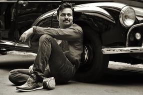 man sitting by the car