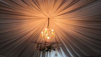 Chandelier with glowing candles, on the ceiling