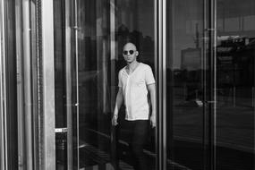 young man comes out of a modern building
