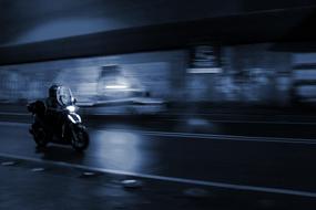 night photo of a riding motorcyclist in Rome