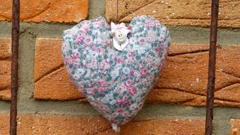 Colorful and beautiful heart decoration with the flower, on the brick wall