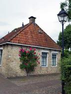 Old building, among the colorful and beautiful plants with flowers, in Bourtange, Netherlands