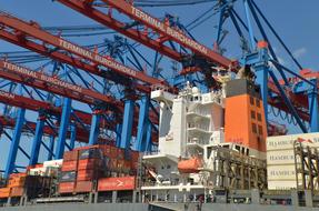 Colorful containers and cranes in the port of Hamburg, Germany, under the blue sky