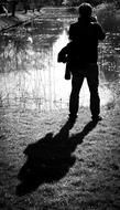 Black and white photo with the back view of the person, taking a photo, with the shadow