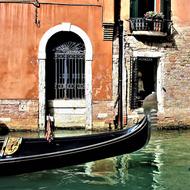 black gondola on the canal in venice on a sunny day