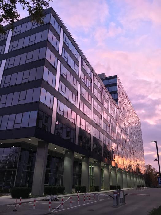 Shiny building, at colorful and beautiful sunset, among the clouds
