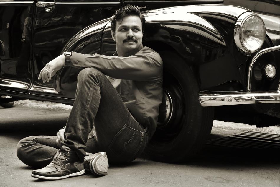 man sitting by the car