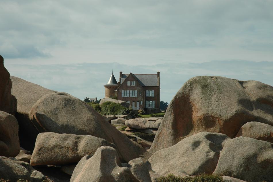 residential building behind stones near the sea