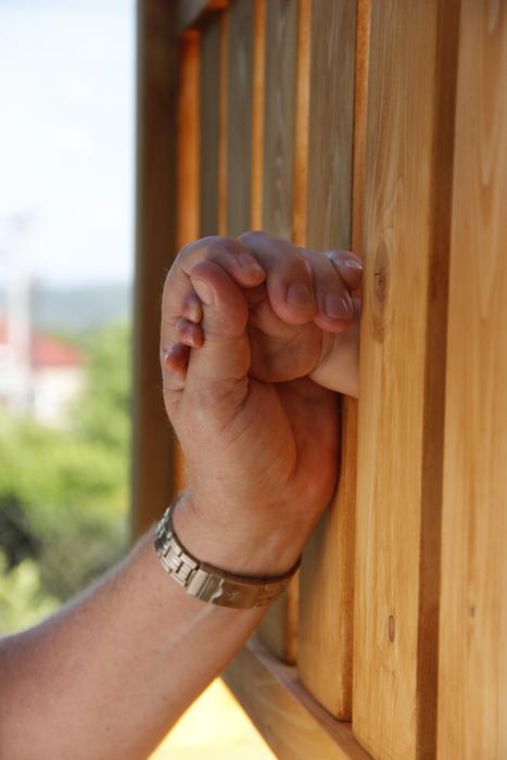 Hand of the person, with the accessory, on the wooden surface