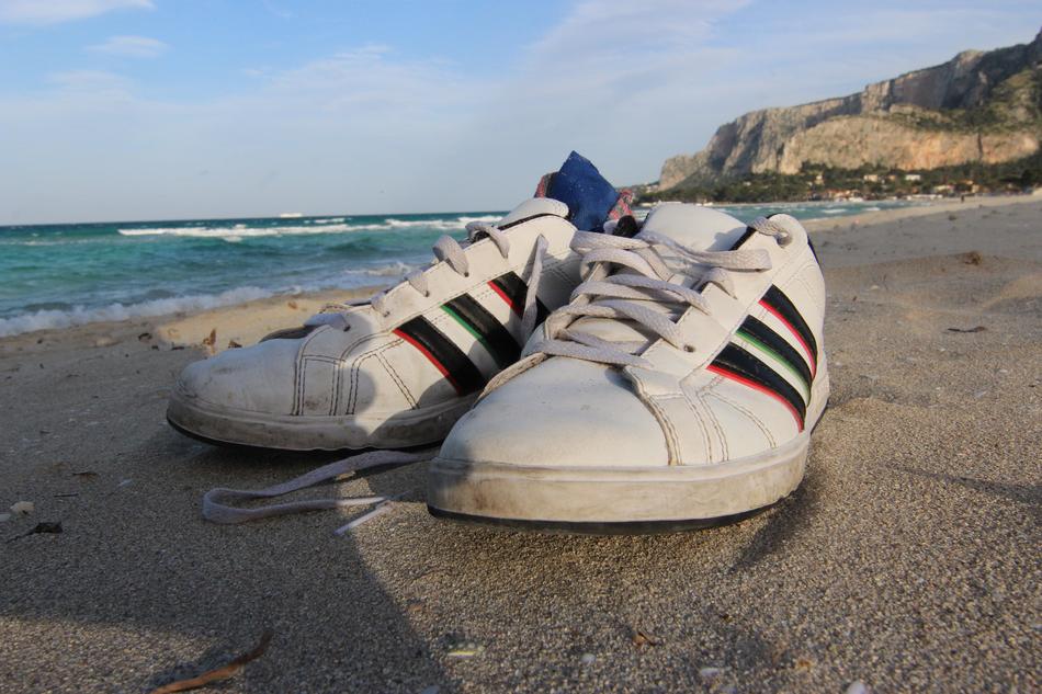 white wet sneakers by the sea