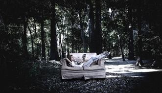girl resting on the couch in the woods