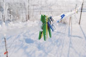 clothespins on a rope in the snow close up