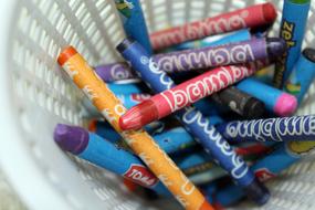 Close-up of the colorful and beautiful crayons with the signs, in the white basket