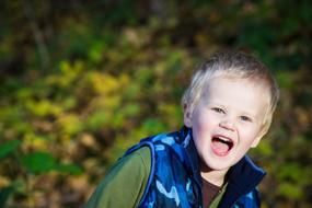 boy with open mouth in nature on a blurred background