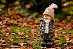 Cute figure of the smiling boy in cap, among the colorful and beautiful forest, in the autumn