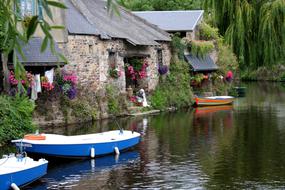 Colorful boats, near the colorful and beautiful houses, among the plants in Pntrieux, Bretagne, France