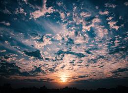 cloudy sky with the sun in the distance