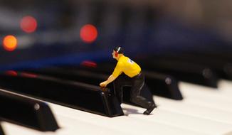 plastic figure of a man on the piano keys