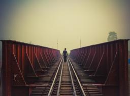 lonely boy walking on the railway bridge