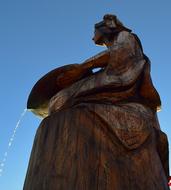 Beautiful and colorful sculpture with the fountain, in sunlight, under the blue sky