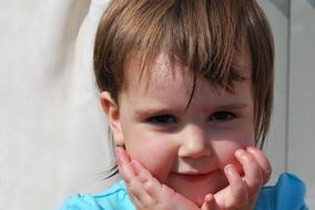 portrait of a happy little girl near the tulle