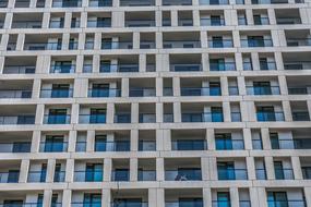 Facade of the concrete building, with the shiny, blue windows