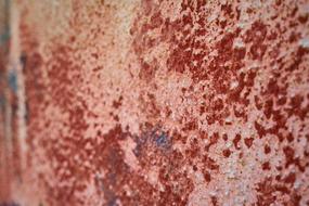 Close-up of the texture of the old, red wall with the paint