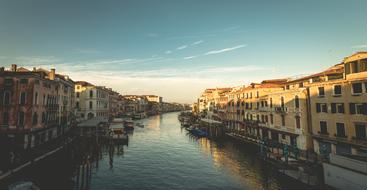 Beautiful canal with the boats, among the colorful buildings, at beautiful sunset