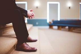 legs of a man in trousers and brown leather boots