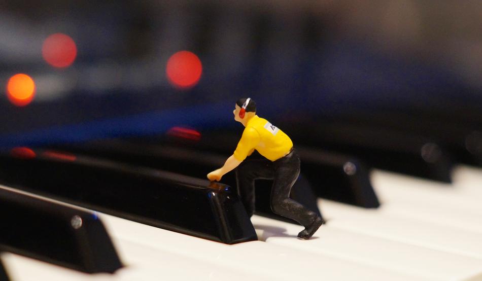 plastic figure of a man on the piano keys