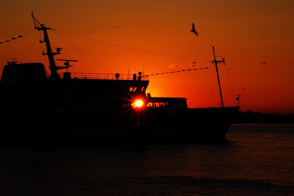 The silhouette of a fishing boat at sunset