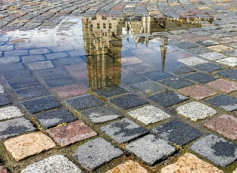 historical architecture reflected in a puddle in Mechelen