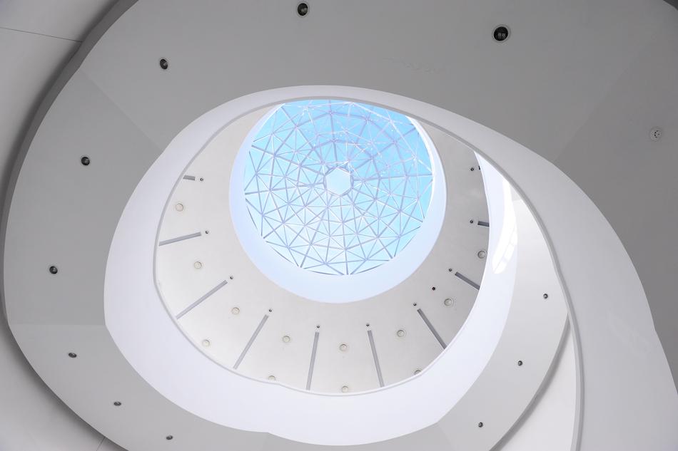 White building with the glass dome, in sunlight, under the blue sky