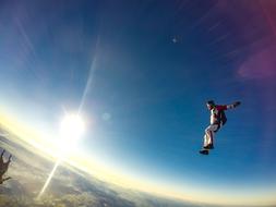 Man, doing skydiving, at beautiful and colorful sunrise