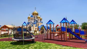 Beautiful and colorful playground near the church in Tarnassos, Cyprus, Greece, among the plants