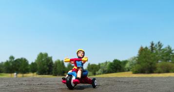 figurine of a boy on a tricycle on the road