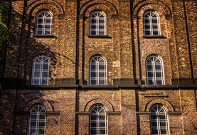 Beautiful facade of the brick house with the windows, in light and shadow