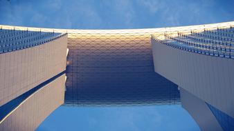 Low angle shot of the shiny building in colorful light, under the blue sky with clouds