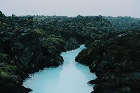 a blue lake in a mountain of trees