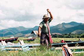 Man among the green field among the beautiful green mountains