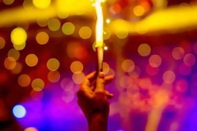 sparkler in hand at colorful Bokeh background
