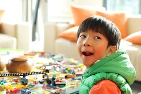 happy boy with lego constructor in blurred background